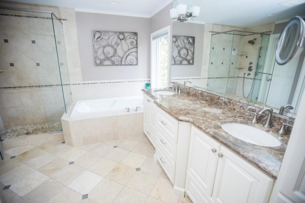 Luxury bathroom with soaking tub, glass shower, and marble countertops