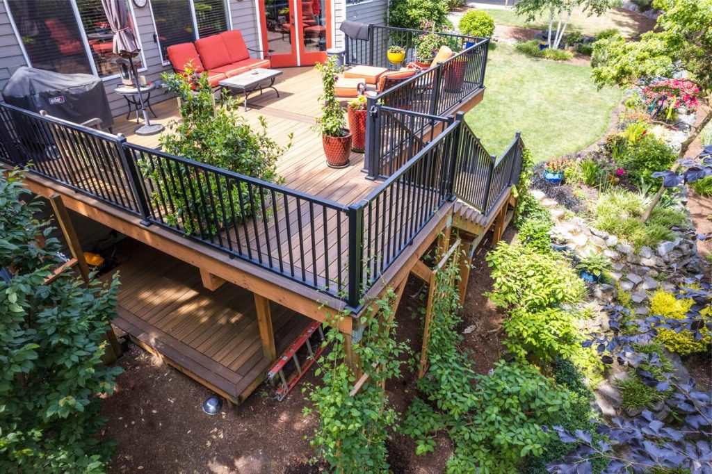 Multi-level composite deck with aluminum railings and lush garden in Newcastle