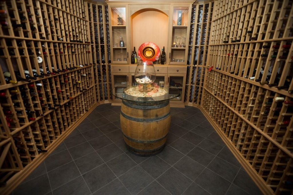 Wine cellar with barrel table centerpiece and arched display cabinet
